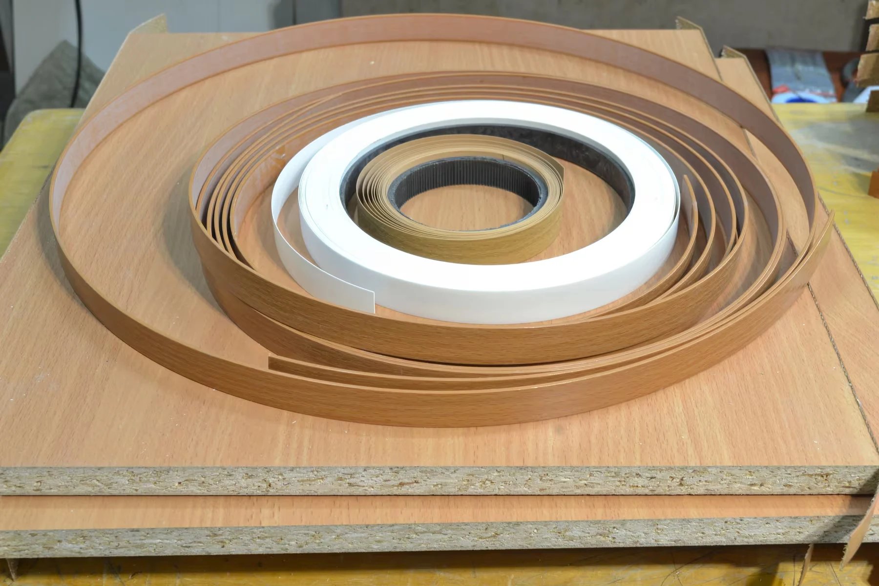 Rollen mit Kantenband auf einer Holzplatte